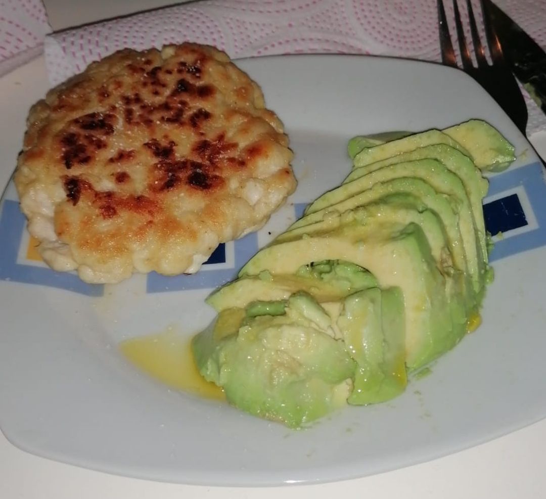 Hamburguesa casera de pollo acompañada de aguacate y aceite Hamburguesa casera de pollo acompañada de aguacate y aceite