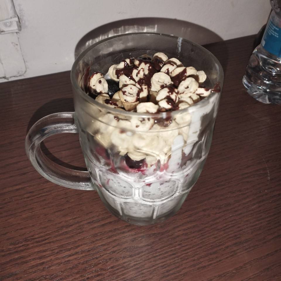 Vaso de yogur con frutas.