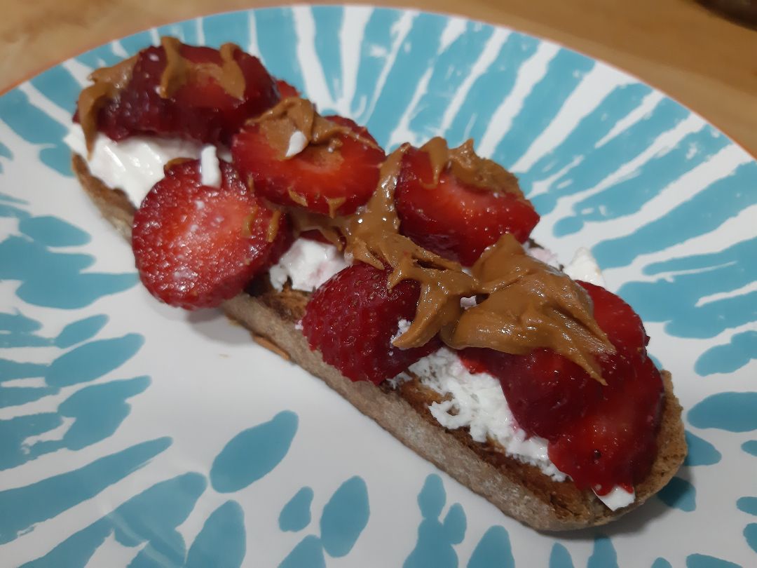 Tostada integral con queso fresco, fresas y crema de cacahuete