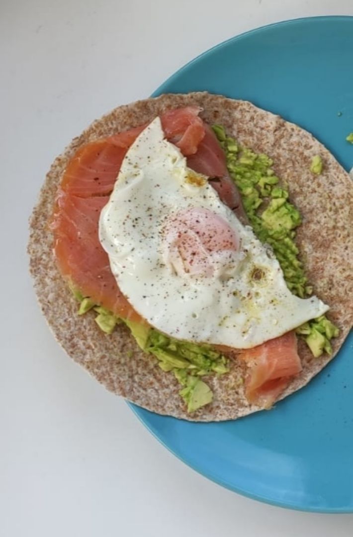 Rollito integral con aguacate, salmón ahumado y huevo a la plancha.