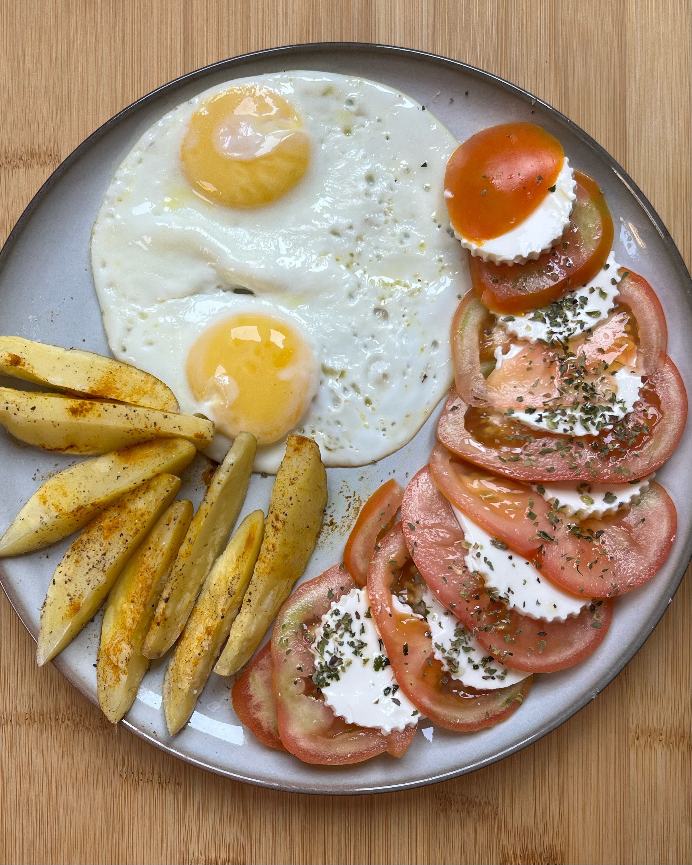 Huevos con patatas y ensalada de tomate y queso fresco