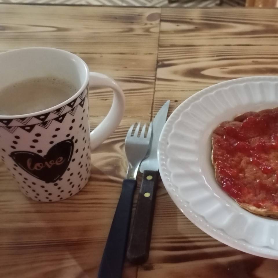 Panqueques de banana con harina integral y mermelada dietética con una tasa de café con leche Panqueques de banana con harina integral y mermelada dietética con una tasa de café con leche