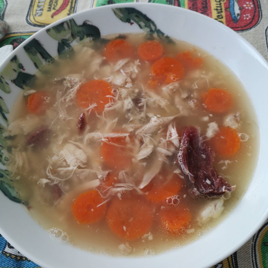 Caldo casero con pollo, jamón desmenuzado y zanahoria