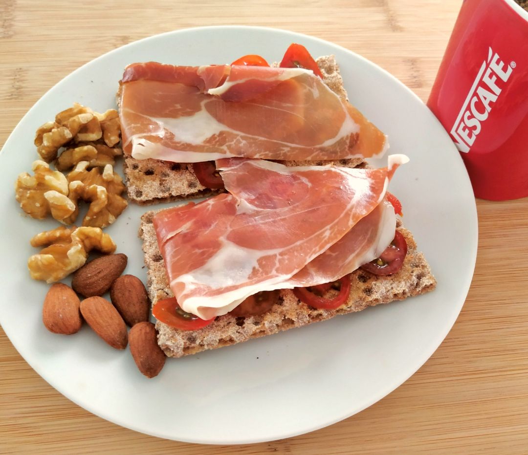 Desayuno tostadas con tomate y jamón y frutos secos