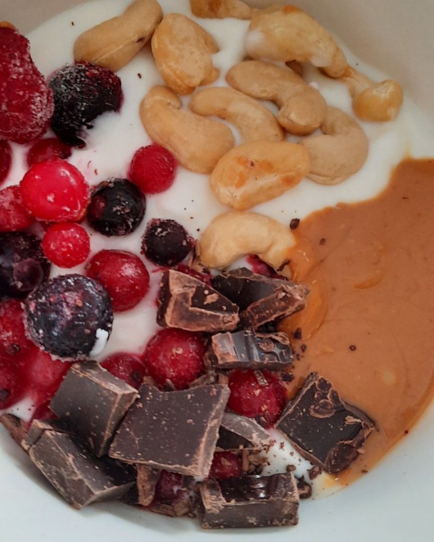 Yogur griego con frutos rojos, anacardos, chocolate y crema de cacahuete Yogur griego con frutos rojos, anacardos, chocolate y crema de cacahuete