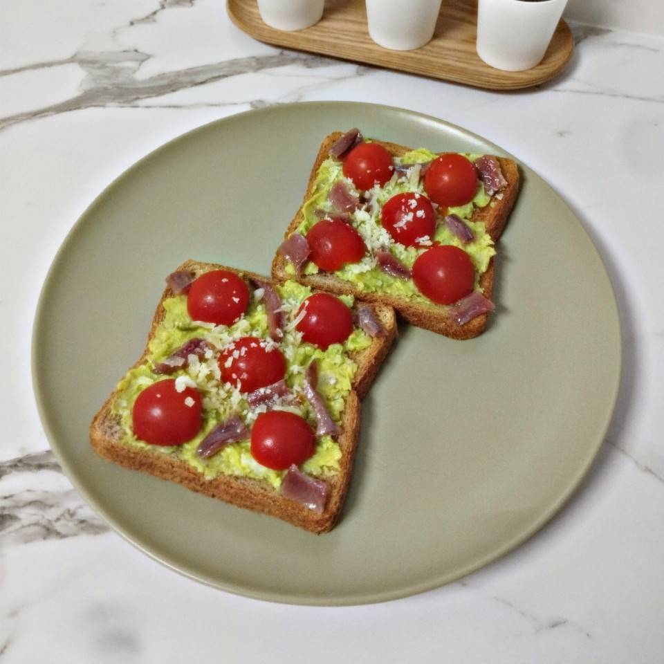 Tosta de aguacate con queso, tomate y anchoas. Tosta de aguacate con queso, tomate y anchoas.