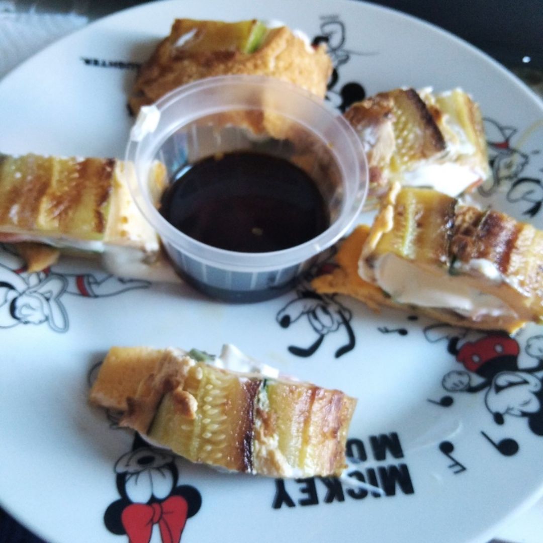 Sushi de calabacín y huevo, relleno de salmón ahumado, aguacate y queso crema. Acompañado de salsa soja Sushi de calabacín y huevo, relleno de salmón ahumado, aguacate y queso crema. Acompañado de salsa soja