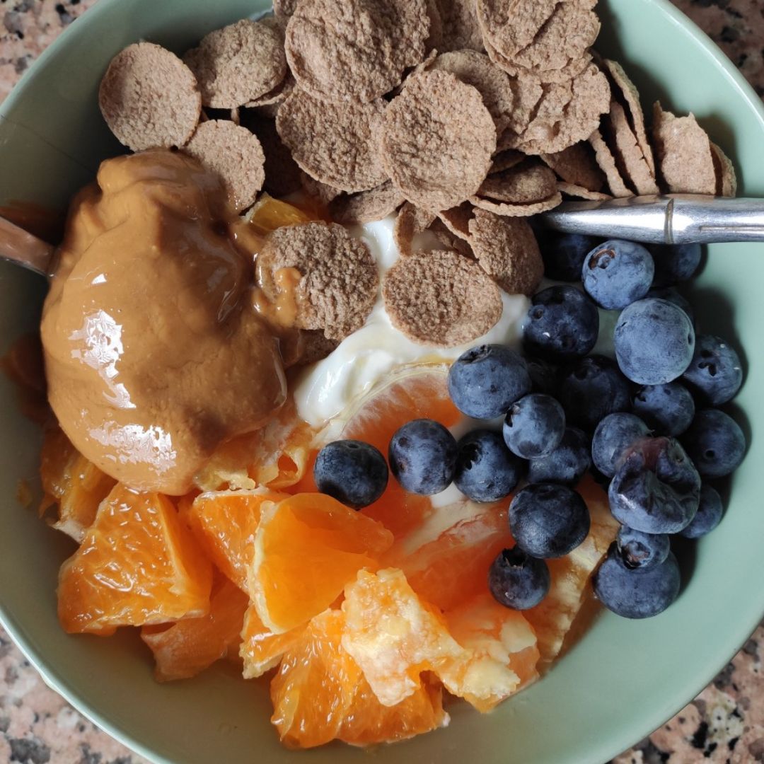 Bol de yogur con naranja, copos de espelta y arándanos