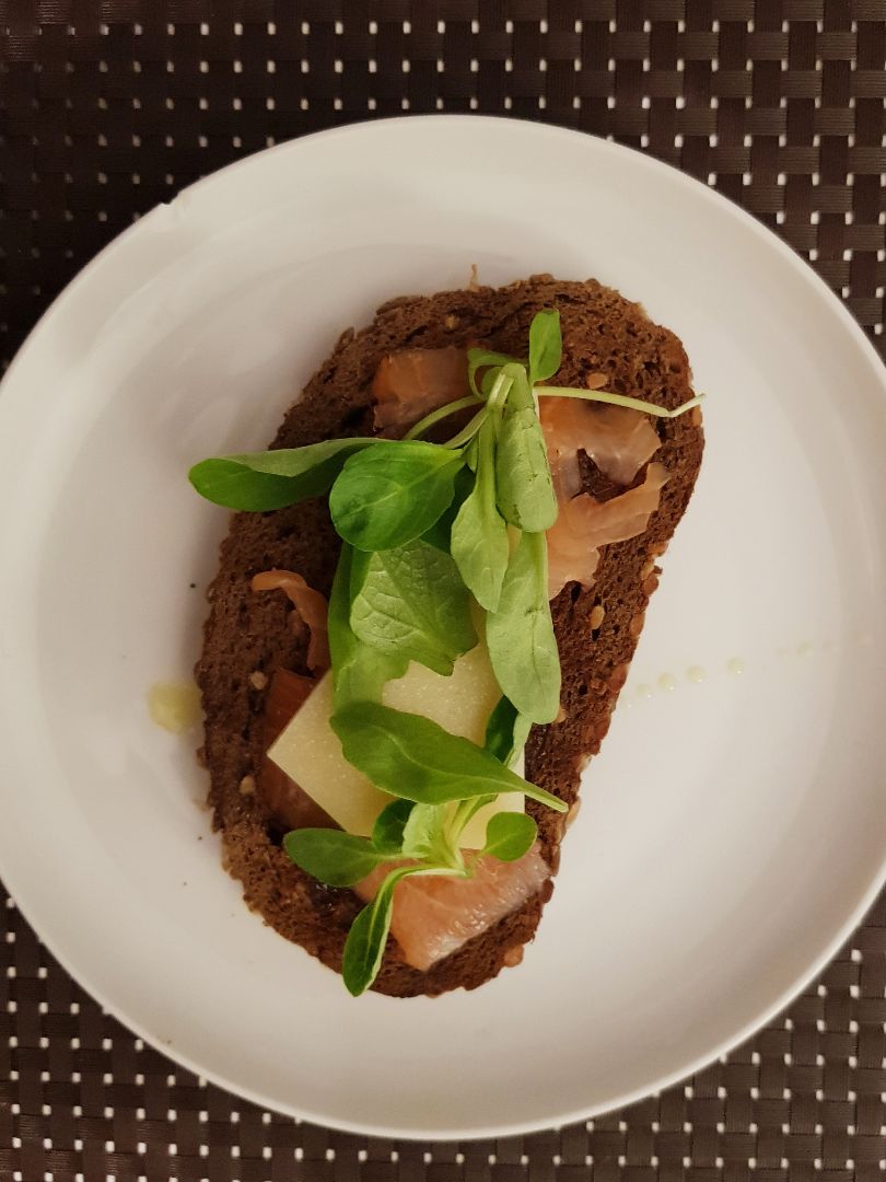 Tostada de pan de centeno con salmón, queso y rúcula