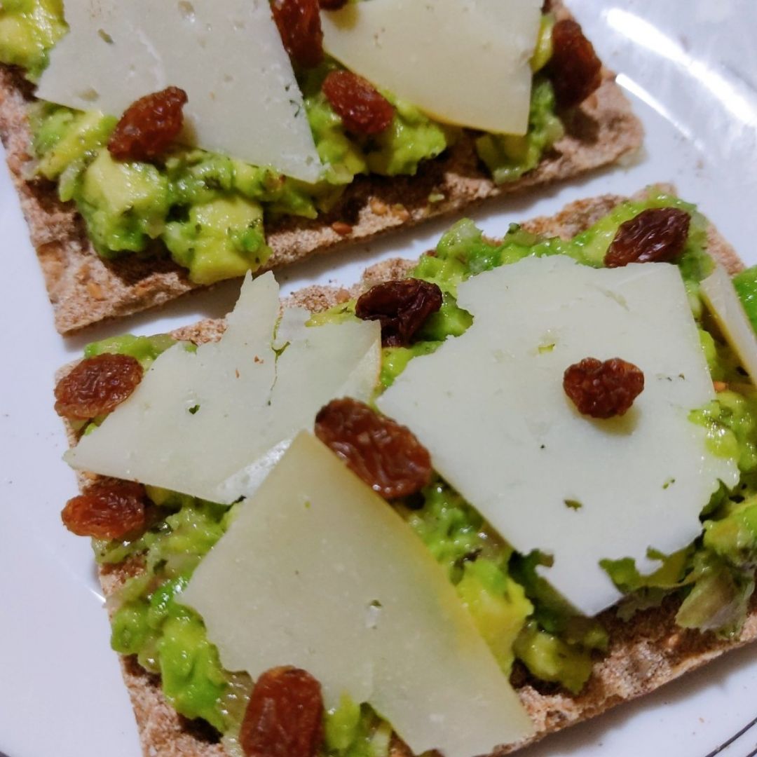 Tostadas con guacamole, queso y uvas pasas