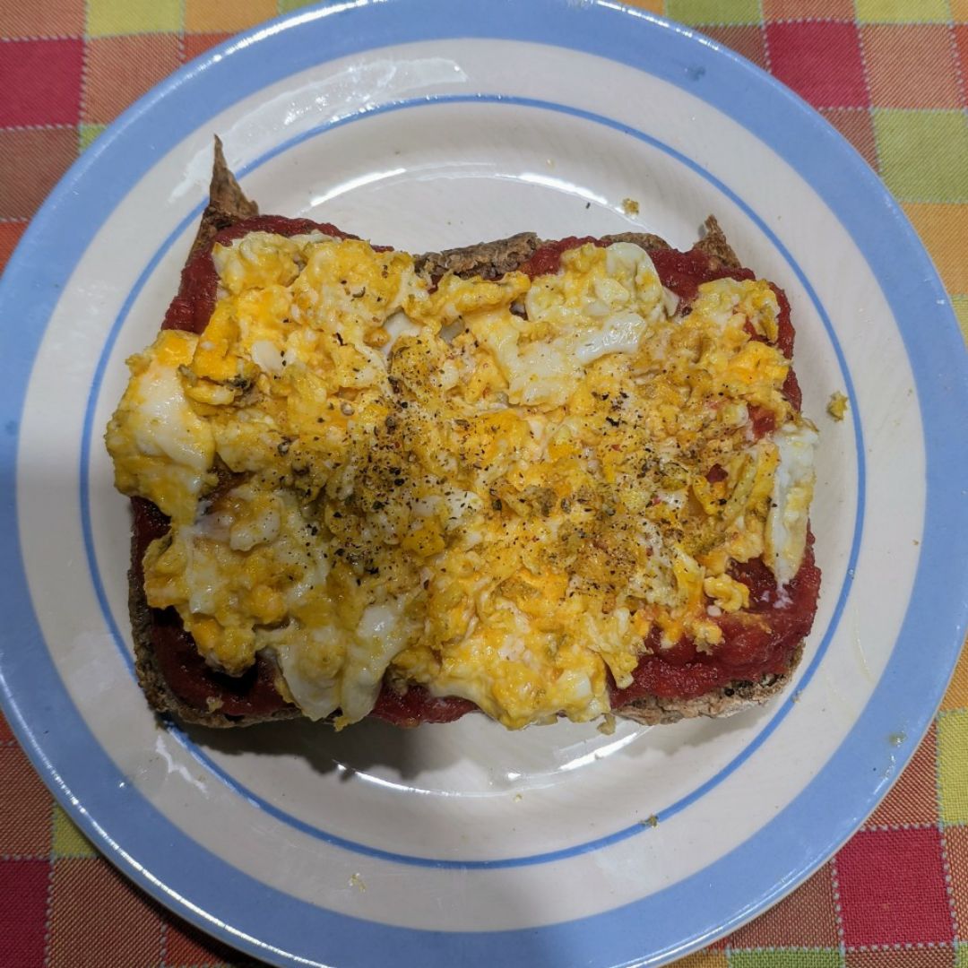 Tostada de pan integral de espelta casero con tomate triturado y huevos revueltos 