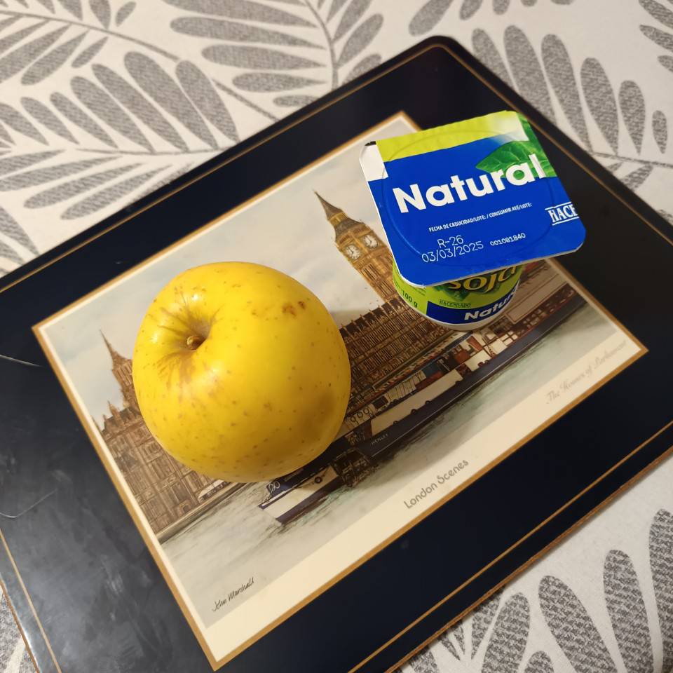 Un yogurt natural de soja y una manzana Un yogurt natural de soja y una manzana