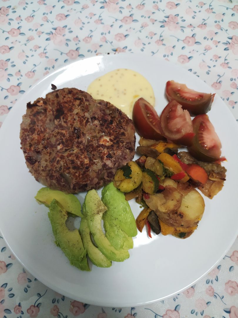 Hamburguesa vegetariana casera con aguacate, tomate y verduras salteadas