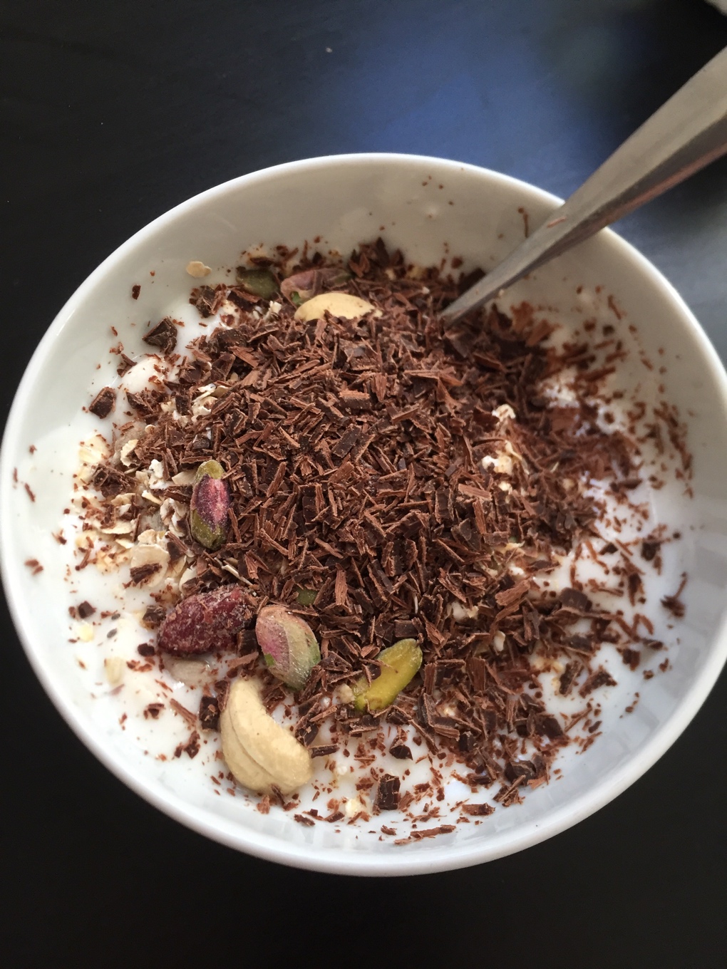 Bol de yogur con copos de avena, chocolate negro, frutos secos y fruta