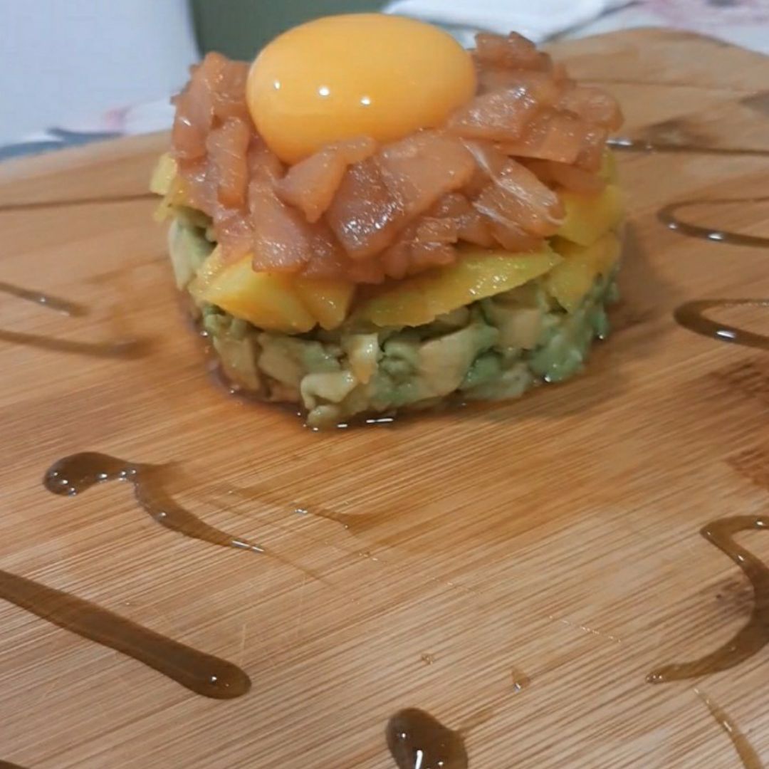 Tartar de aguacate, salmón , mango y coronado con una yema de huevo sobre una base de vinagre de manzana Tartar de aguacate, salmón , mango y coronado con una yema de huevo sobre una base de vinagre de manzana