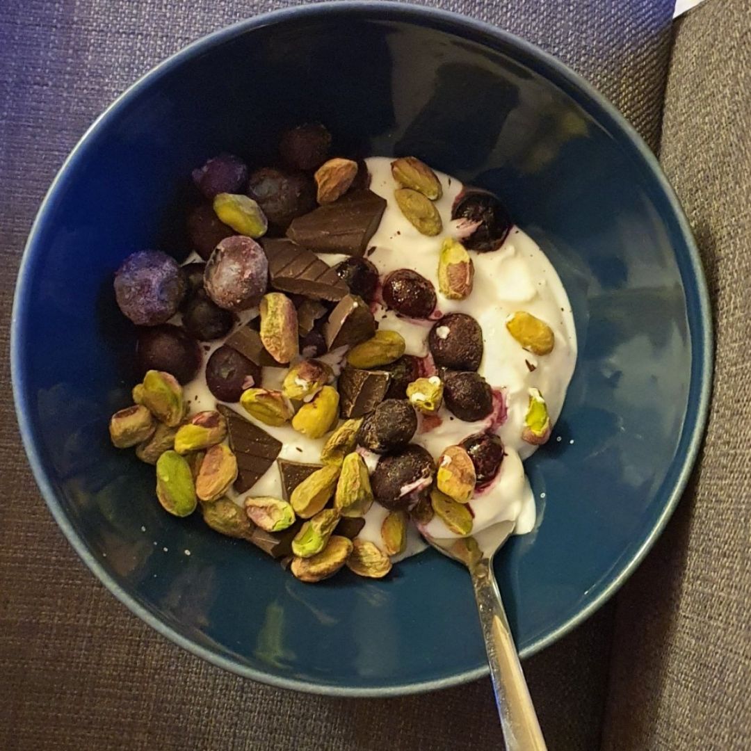 Yogur con arándanos, pistachos y chocolate.