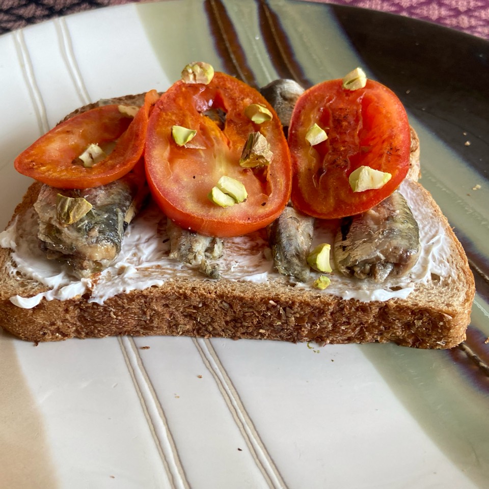 Tostada de sardinas con crema de queso, tomate asado y pistachos Tostada de sardinas con crema de queso, tomate asado y pistachos