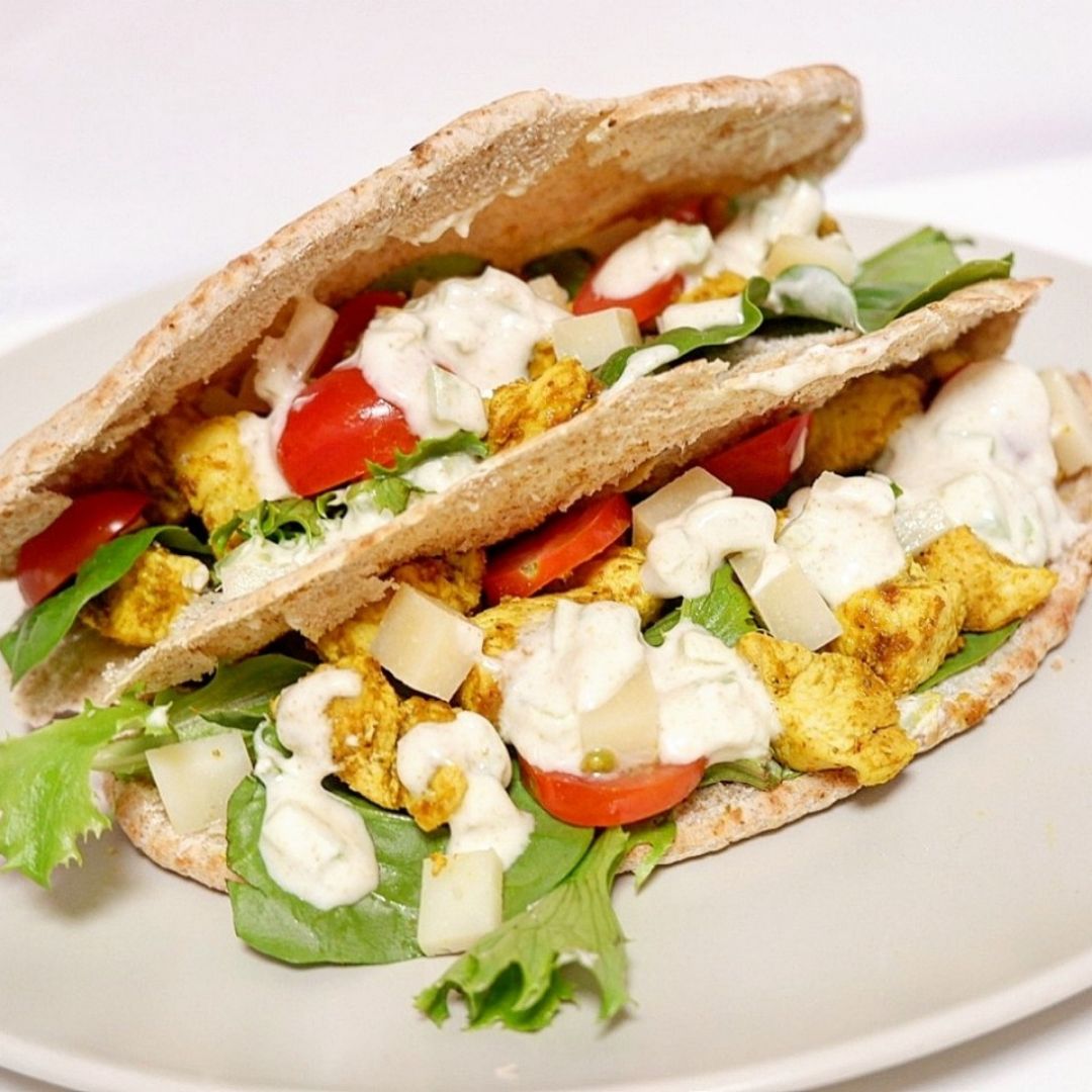 Pan de pita con pollo especiado, brotes, cherris, queso y salsa de yogur Pan de pita con pollo especiado, brotes, cherris, queso y salsa de yogur