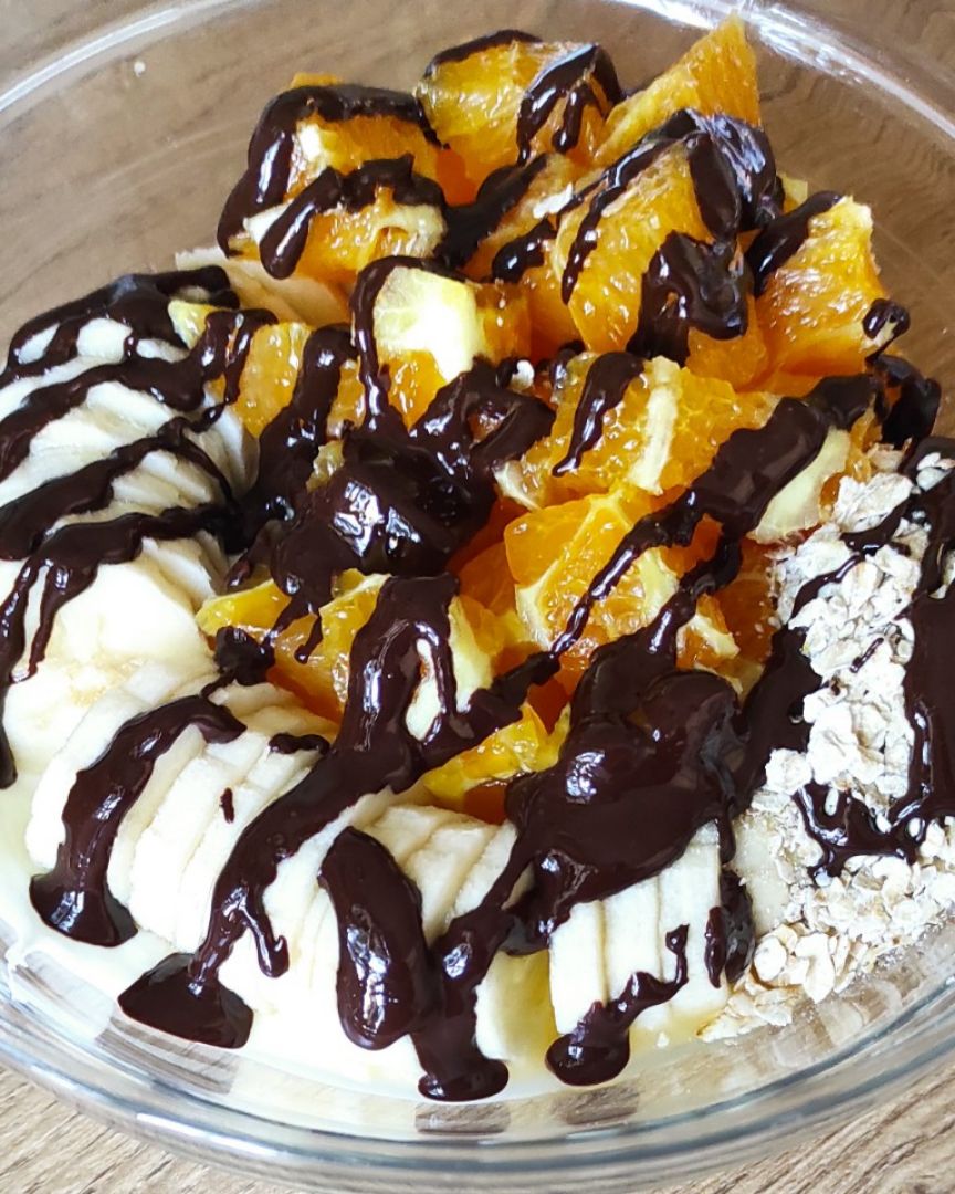 Bol de yogur con naranja, plátano, avena y chocolate Bol de yogur con naranja, plátano, avena y chocolate