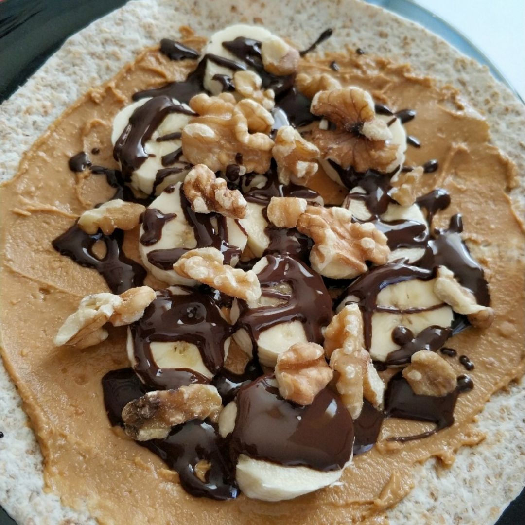Tortilla integral con crema de cacahuate, plátano, chocolate 85% y nueces Tortilla integral con crema de cacahuate, plátano, chocolate 85% y nueces