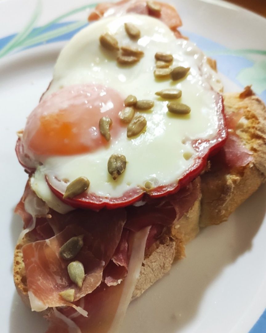Tosta de jamón, tomate, huevo a la plancha con pimiento y pipas Tosta de jamón, tomate, huevo a la plancha con pimiento y pipas