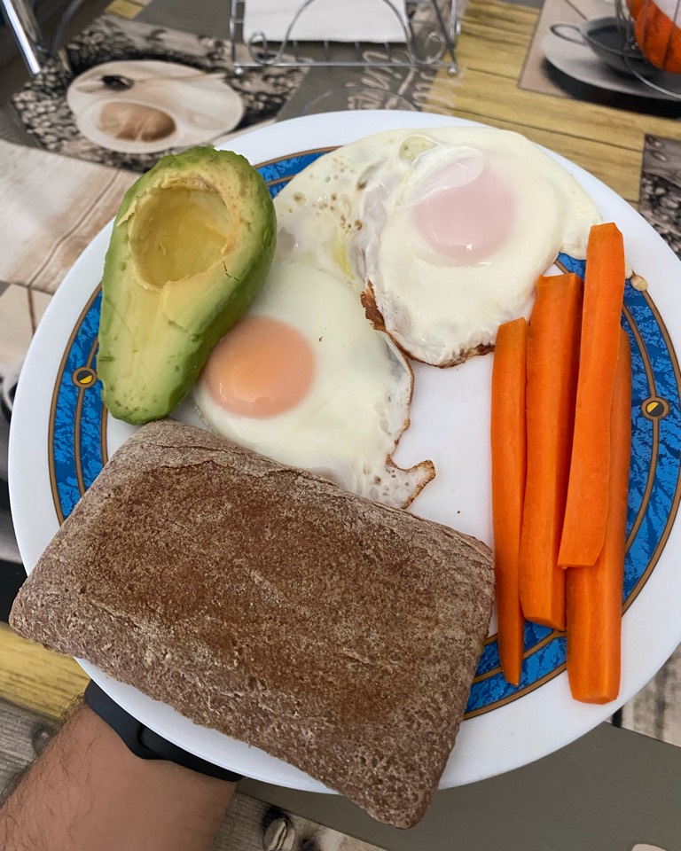 Huevos con pan integral, aguacate y zanahoria cruda