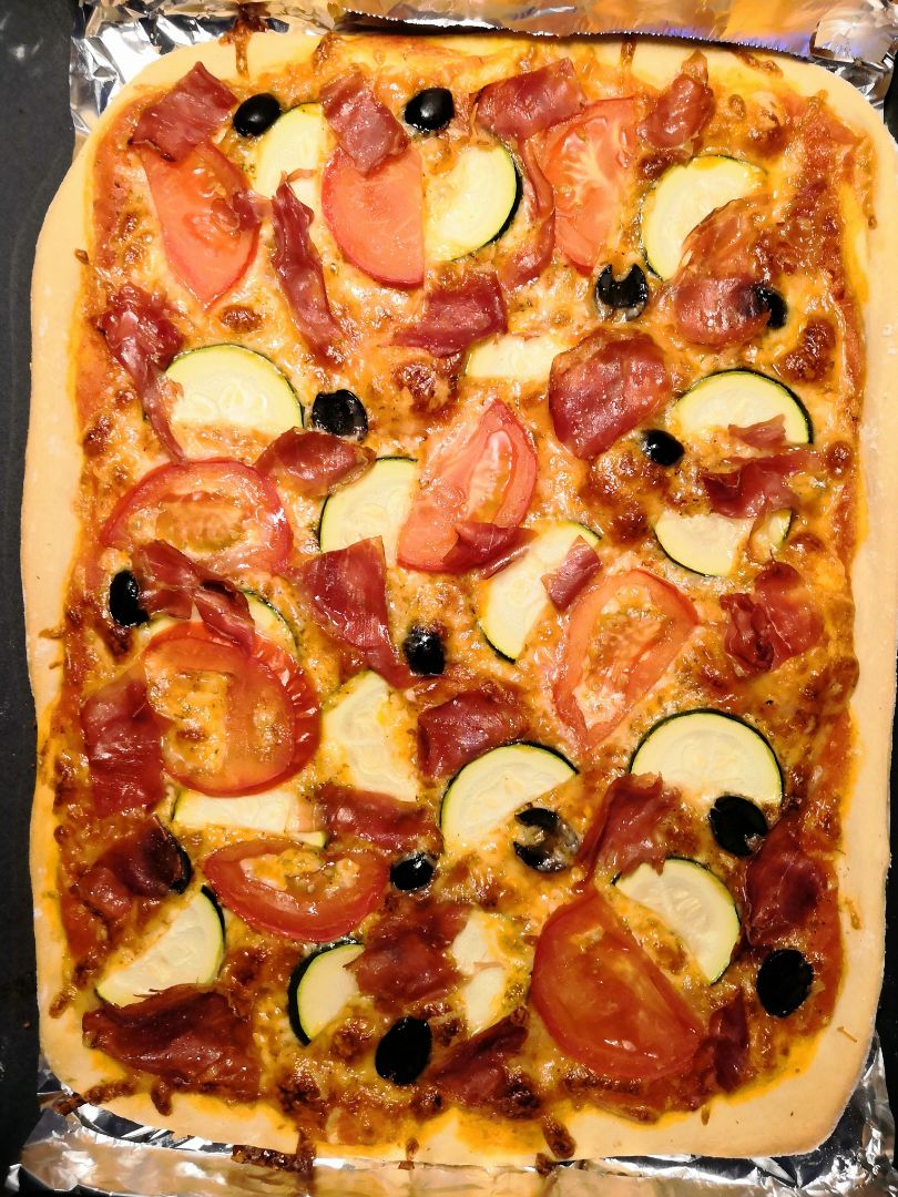 Pizza de tomate y jamón. 
