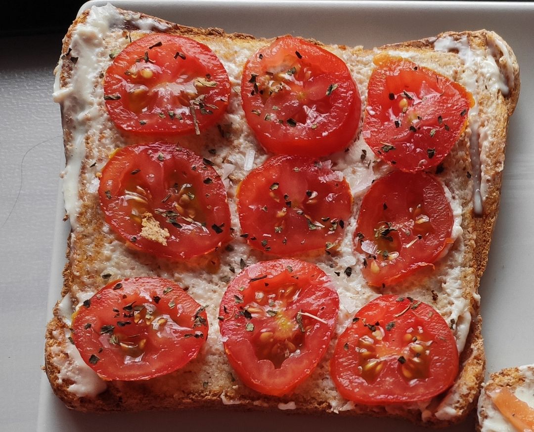 Tostada de pan integral con queso, tomate cherry y albahaca Tostada de pan integral con queso, tomate cherry y albahaca