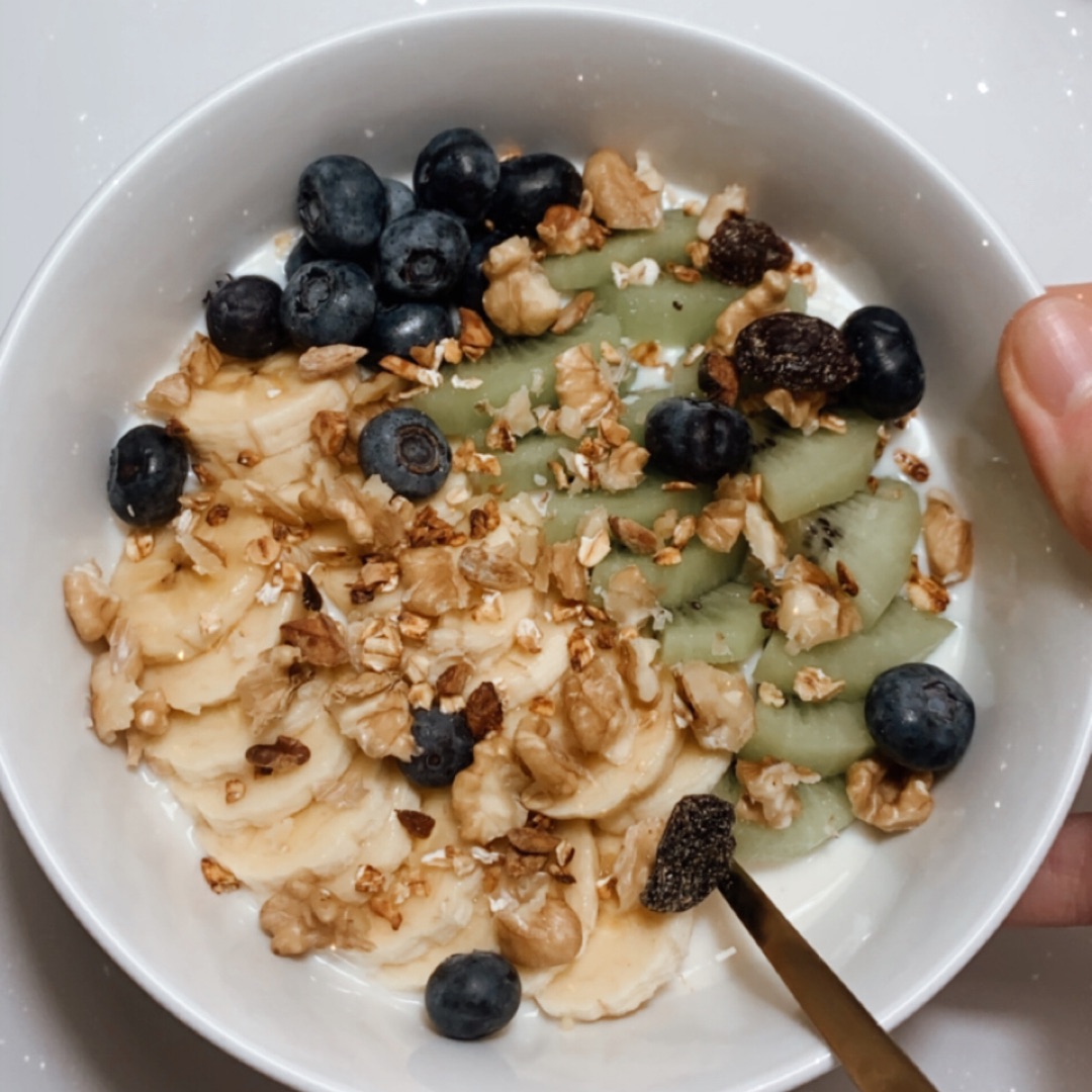 Yogur alpro con granola, nueces, plátano, arándanos y kiwi