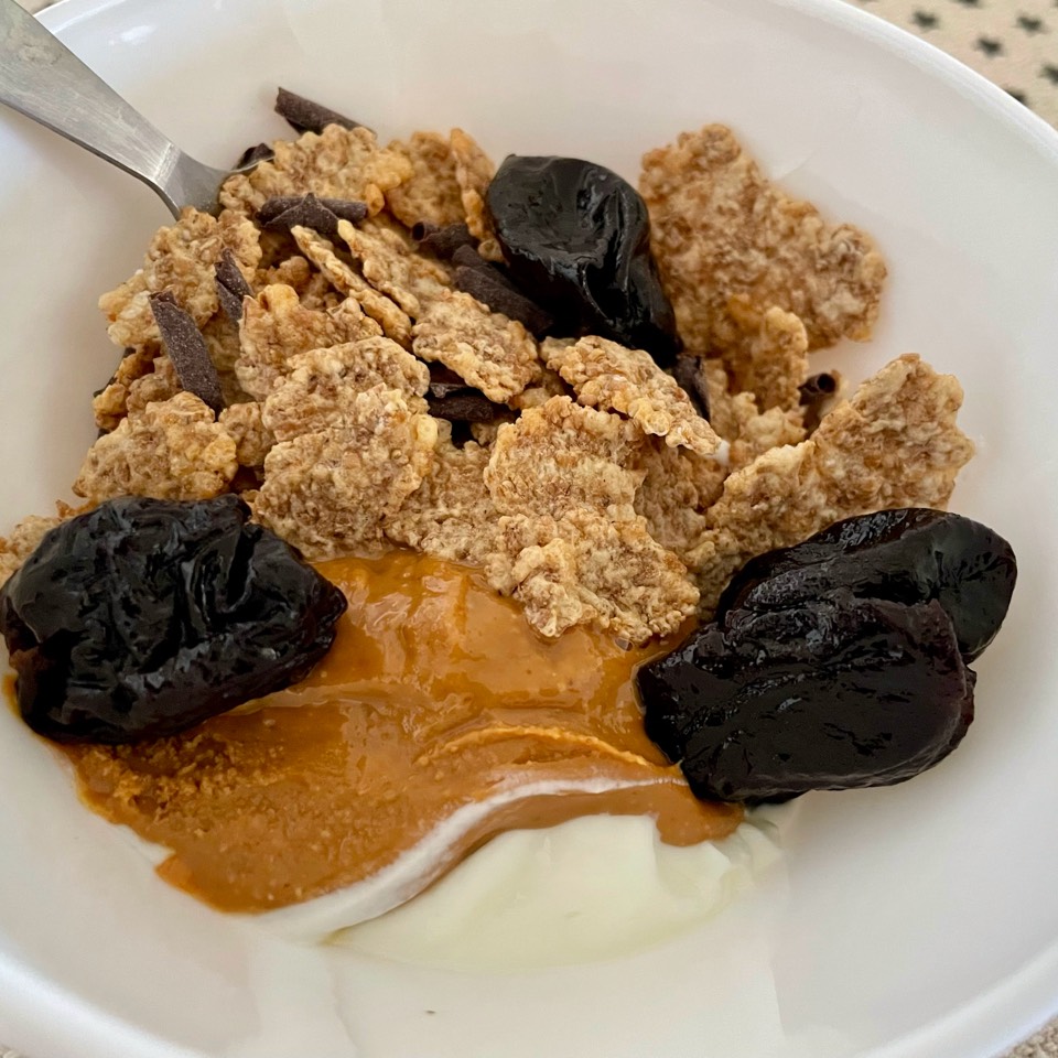 Bol de yogur con cereales, ciruelas y crema de cacahuete Bol de yogur con cereales, ciruelas y crema de cacahuete