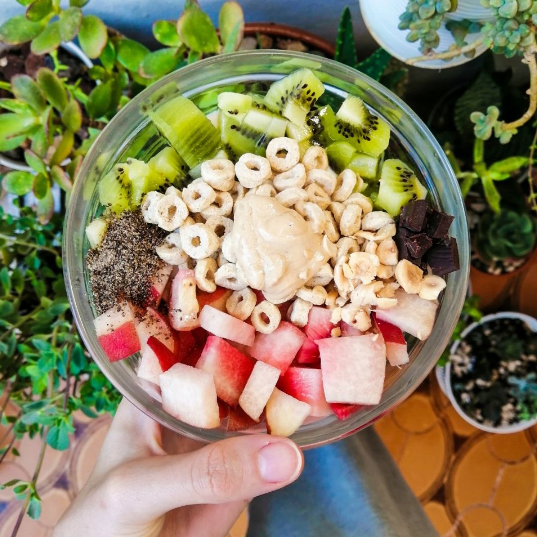 Bowl de yogur con fresas, kiwi, chocolate, crema de cacahuete, cereales y semillas