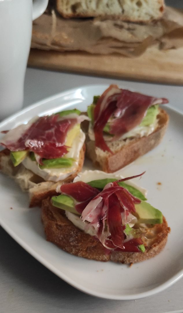 Tostadas con aguacate, rulo de cabra y jamón
