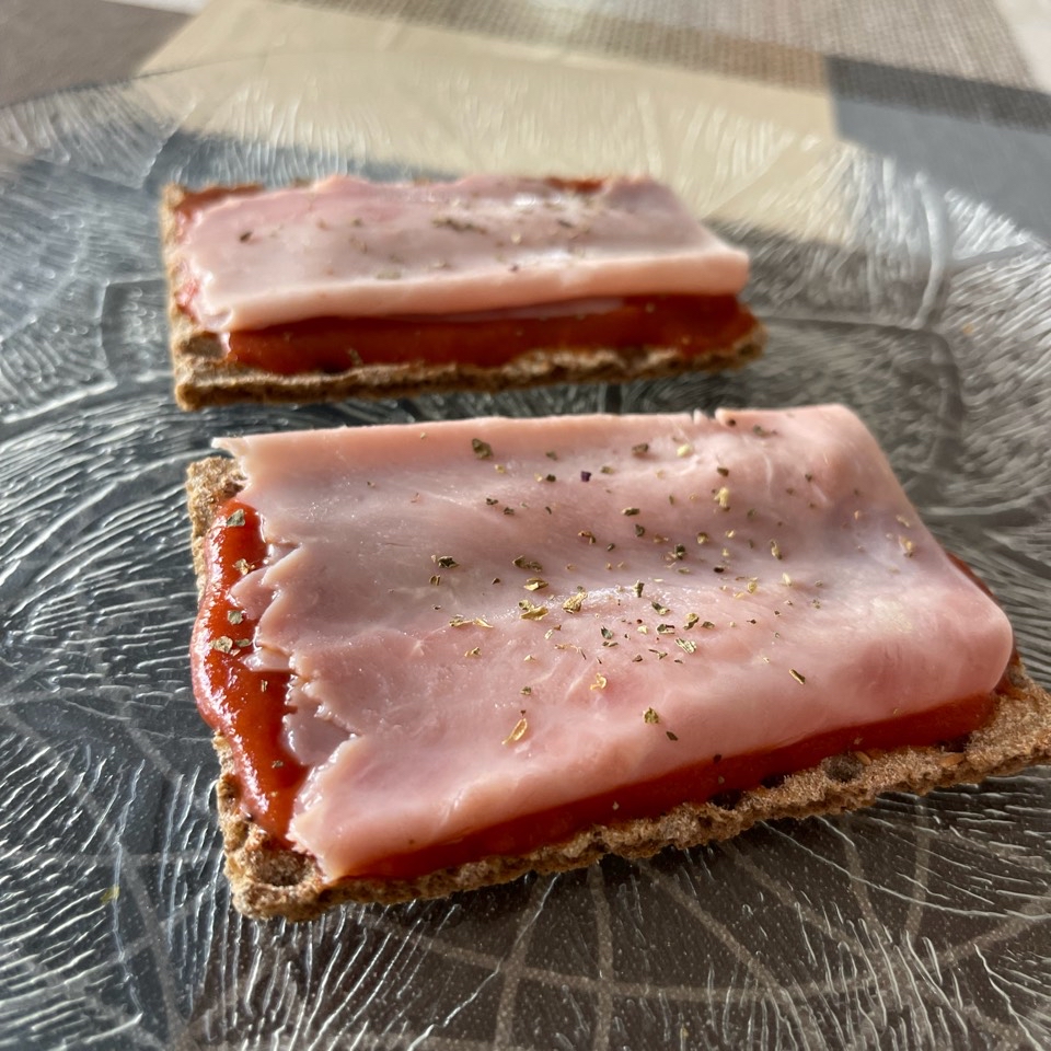 Tostas de pan fibra y sésamo con tomate, jamón cocido y albahaca Tostas de pan fibra y sésamo con tomate, jamón cocido y albahaca