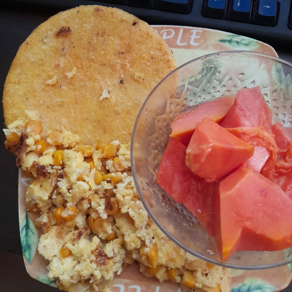 Huevos revueltos con maíz ,arepa y papaya