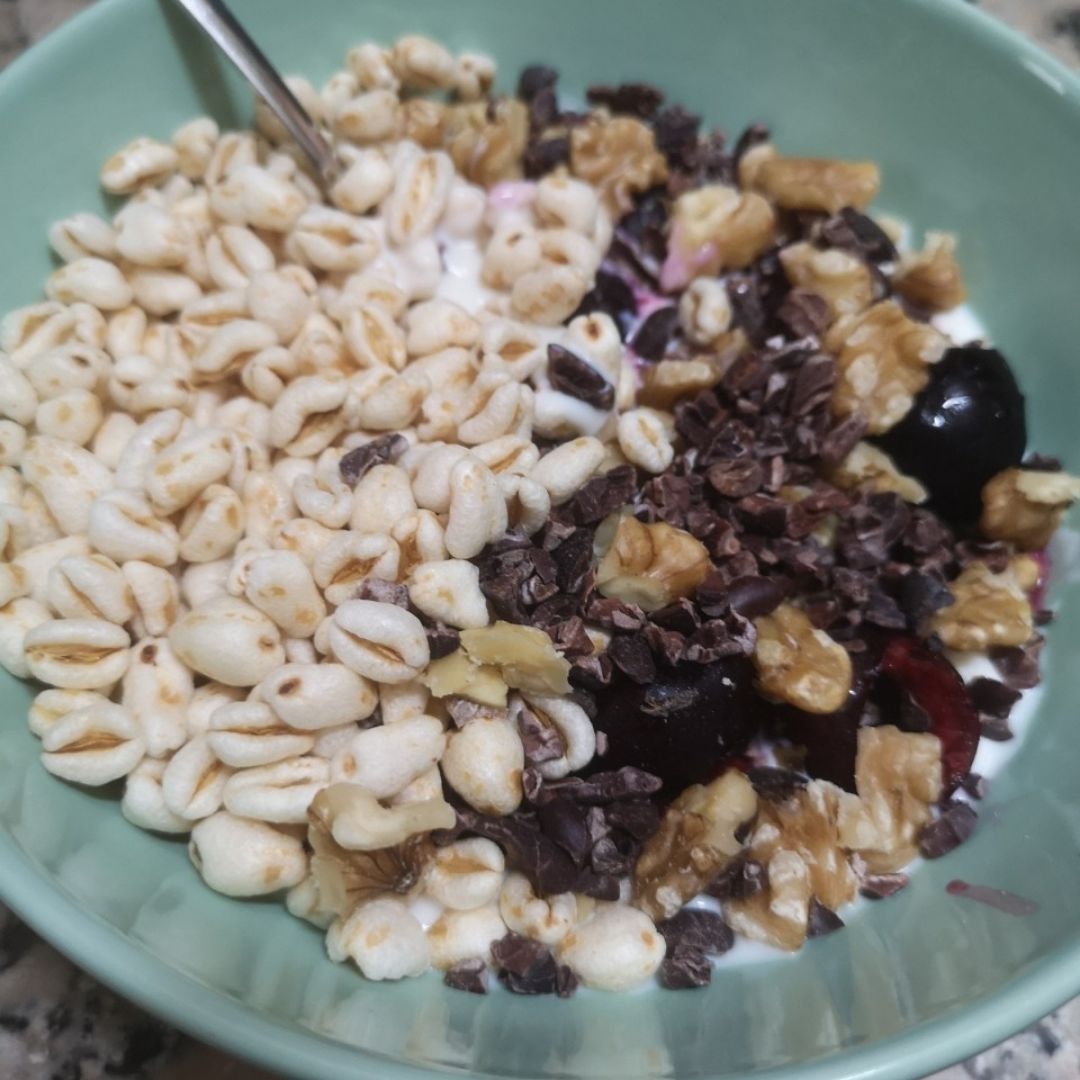 Bol de yogur con cerezas, trigo hinchado, nueces y nibs de cacao Bol de yogur con cerezas, trigo hinchado, nueces y nibs de cacao