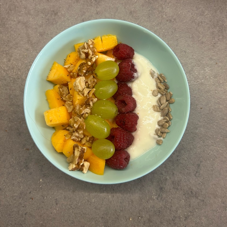Bol de yogur con melocotón, frambuesas, uvas y nueces Bol de yogur con melocotón, frambuesas, uvas y nueces