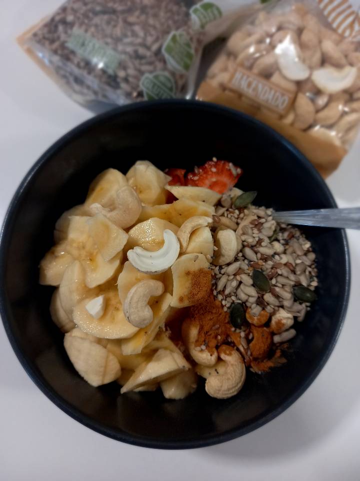 Bowl yogurt proteico con semillas, nueces de macadamia, canela, fresas y plátano Bowl yogurt proteico con semillas, nueces de macadamia, canela, fresas y plátano