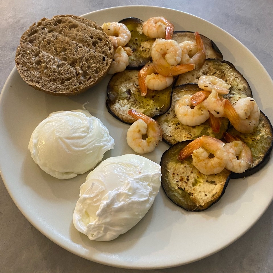 Plato combinado: berenjena, langostinos y huevo poché