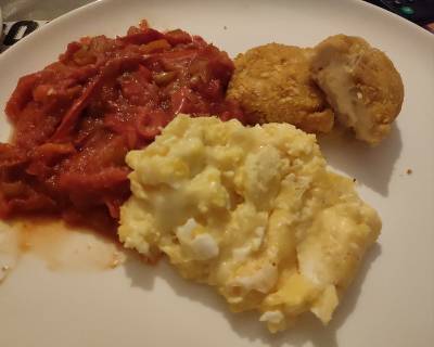 Plato combinado de pollo empanado relleno de queso, verduras estilo pisto y huevos revueltos con queso.