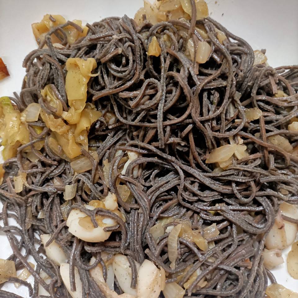 Fideos de soja negra con calabacín, cebolla y sepia