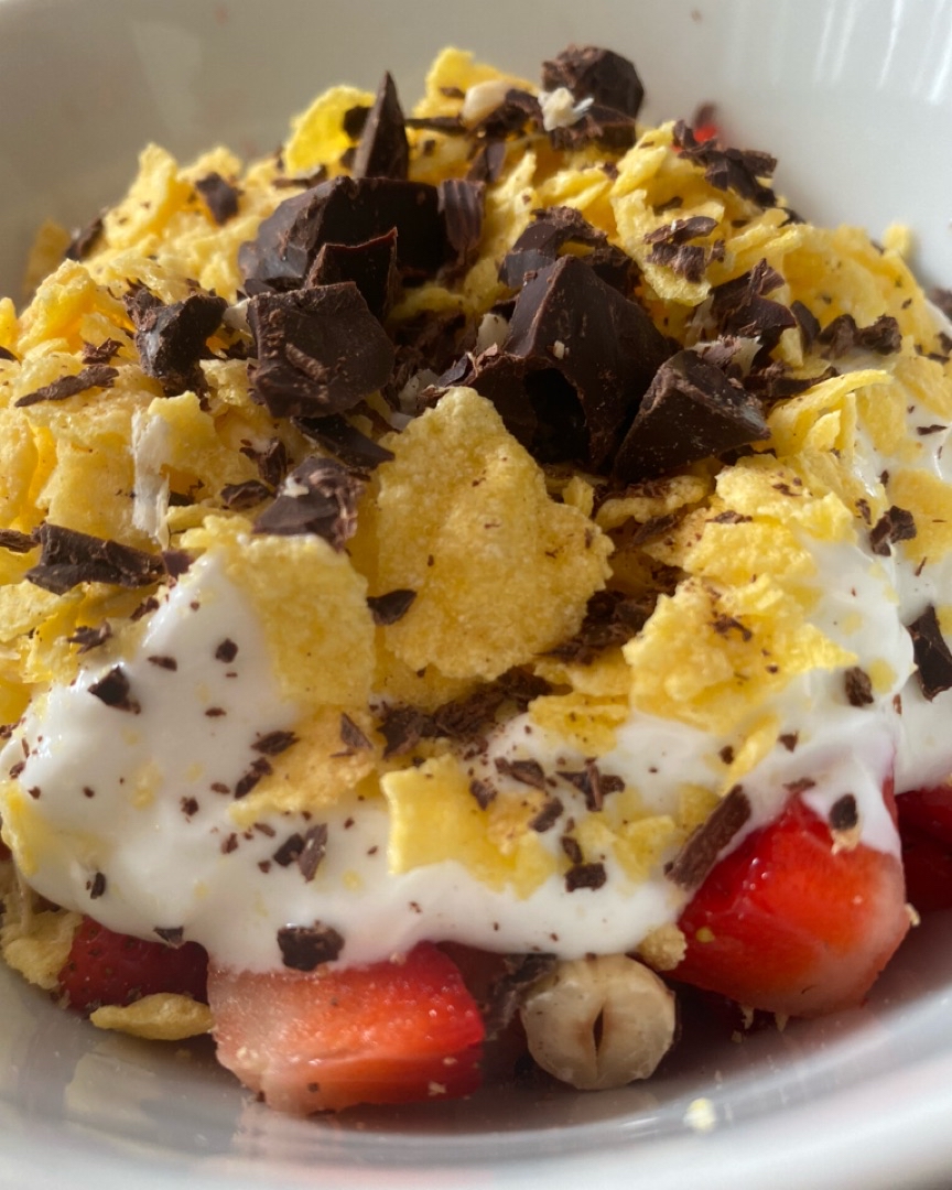 Yogur con fresas, cereales, frutos secos y chocolate