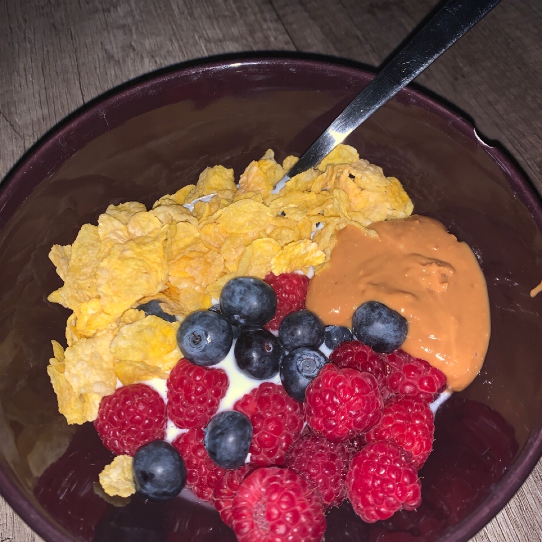 Yogur proteico con frutos rojos, copos y crema de cacahuete Yogur proteico con frutos rojos, copos y crema de cacahuete