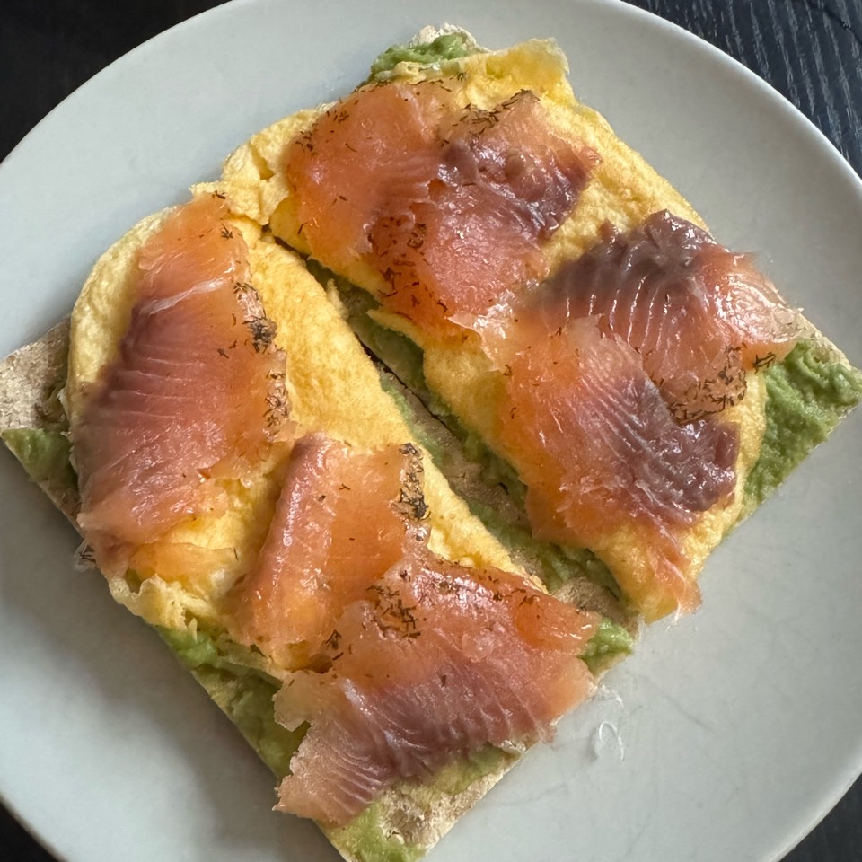 Tostada con guacamole, tortilla francesa y salmón marinado Tostada con guacamole, tortilla francesa y salmón marinado