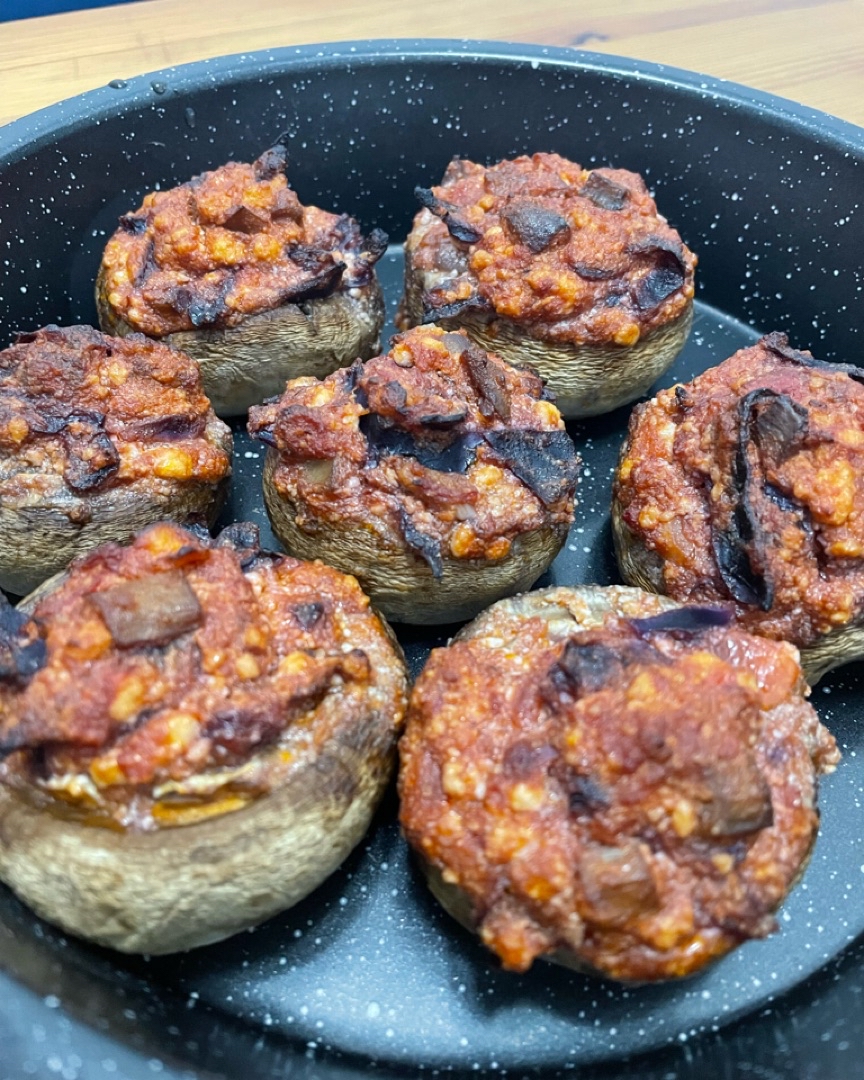 Champiñones rellenos de salsa de tomate, ajo, col lombarda y requesón