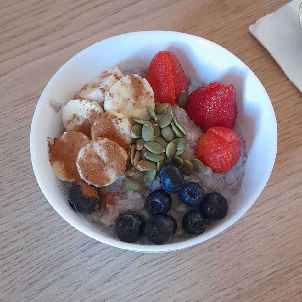 Porridge con frutos rojos, platano y pipas de calabaza