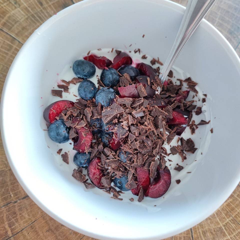 Yogur proteico natural con cerezas y chocolate Yogur proteico natural con cerezas y chocolate