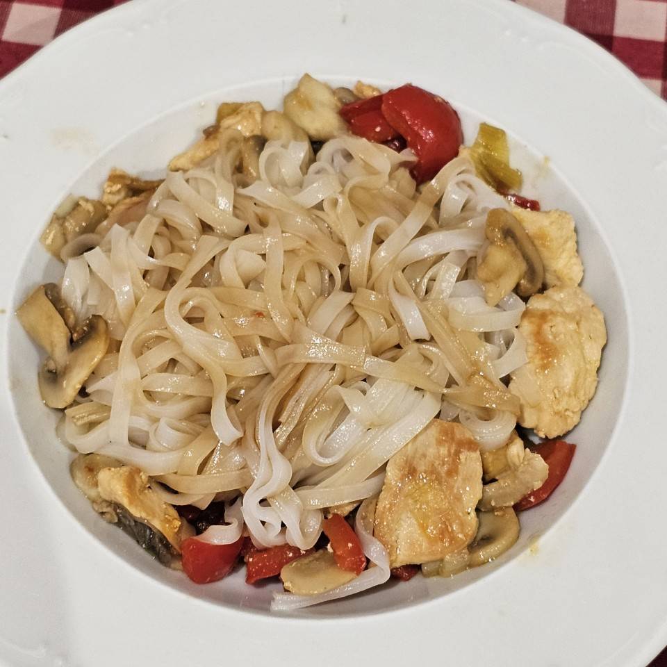 Noddles de arroz con pollo y verduras estilo oriental Noddles de arroz con pollo y verduras estilo oriental