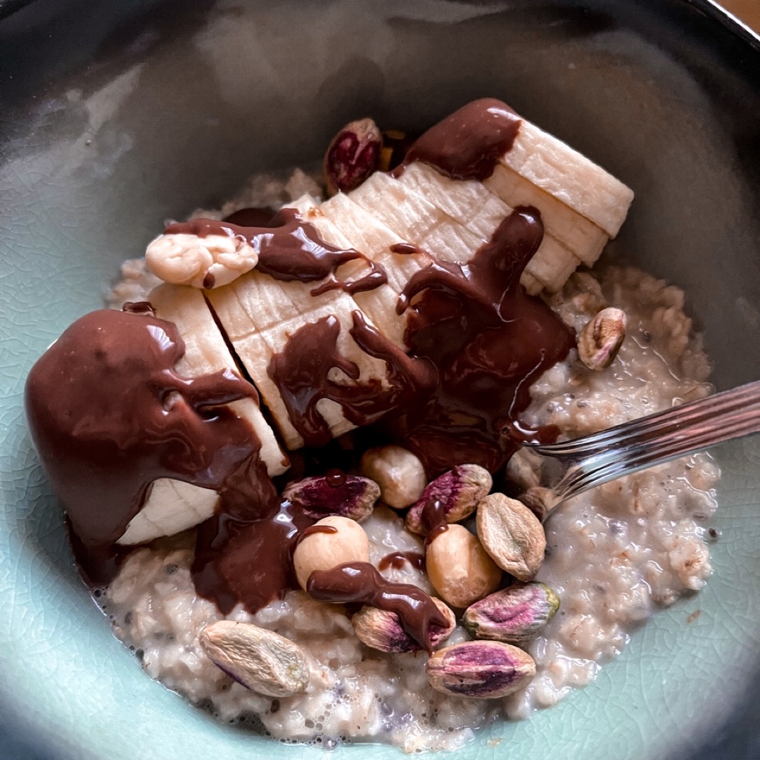 Gachas de avena y chía con plátano, chocolate 85% y pistachos 