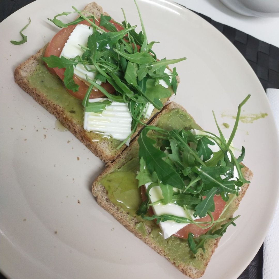 Tostadas de guacamole con queso fresco, tomate y rucula