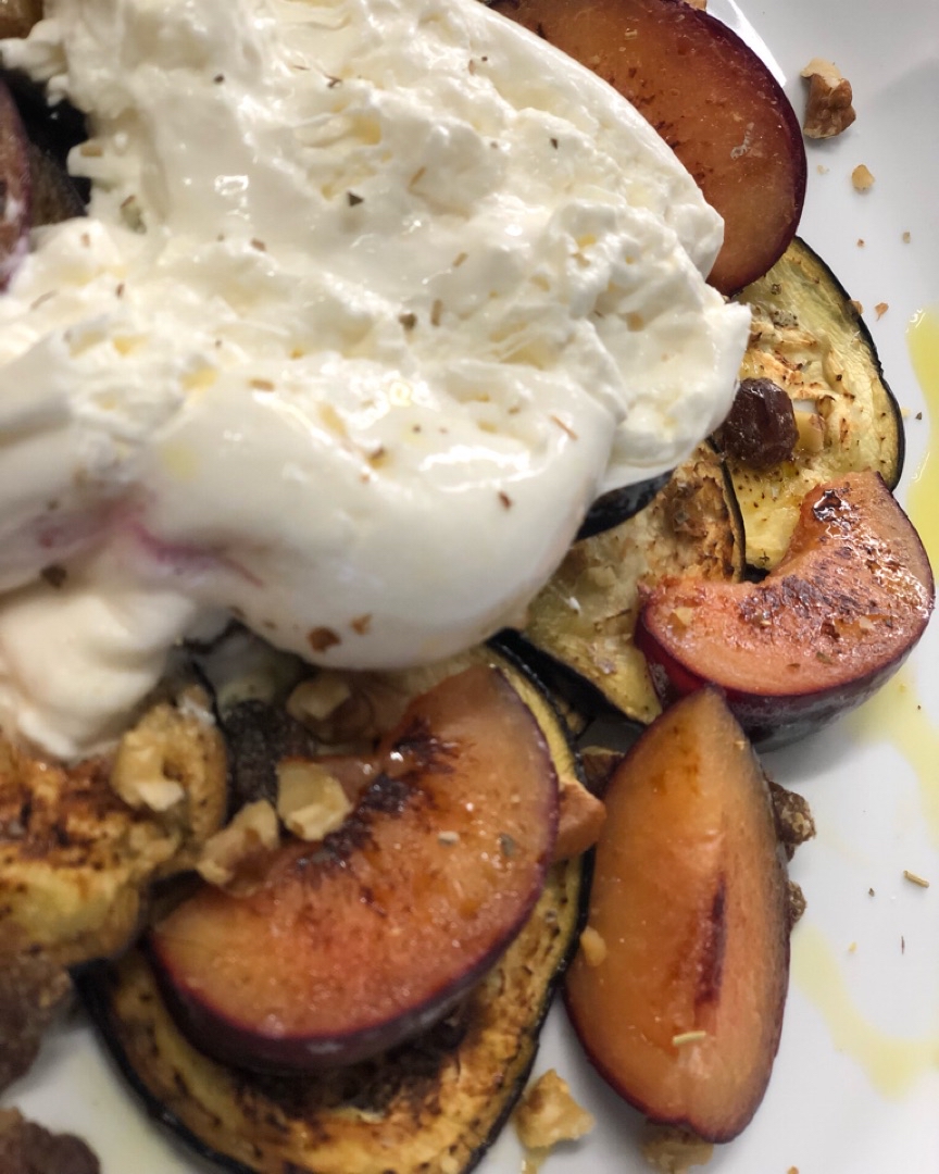 Ensalada templada de berenjena , burrata y ciruela roja .